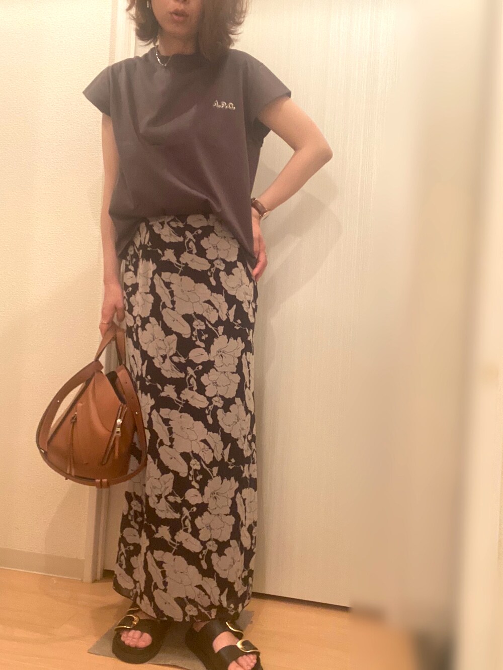 グリーン系のTシャツ/カットソー、ブラック系のスカート、ブラウン系のサンダルを着用したレディースの夏コーディネートの2枚目の写真