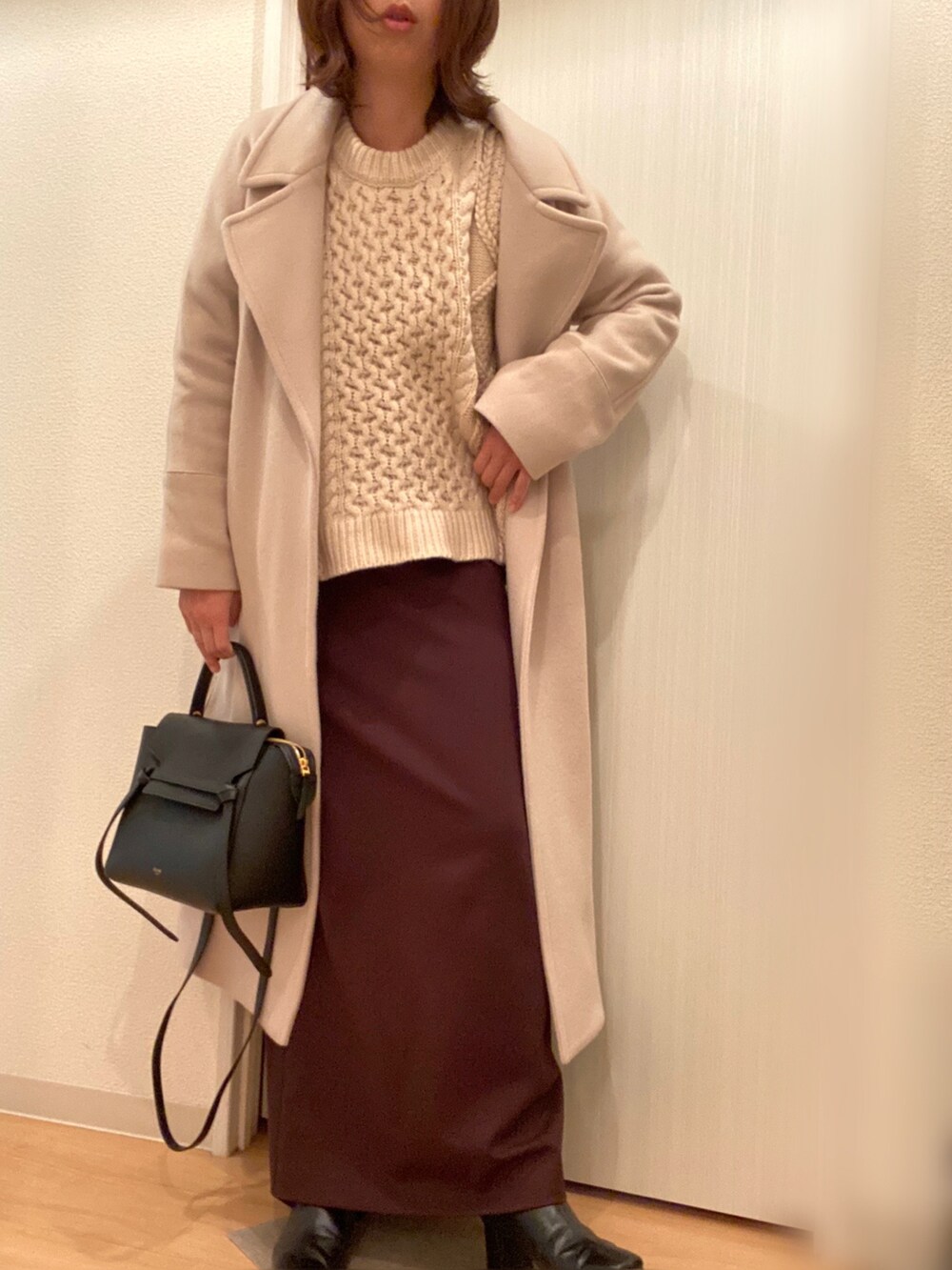 ホワイト系のニット/セーター、ブラウン系のスカート、ベージュ系のその他アウターを着用したレディースの冬コーディネートの3枚目の写真
