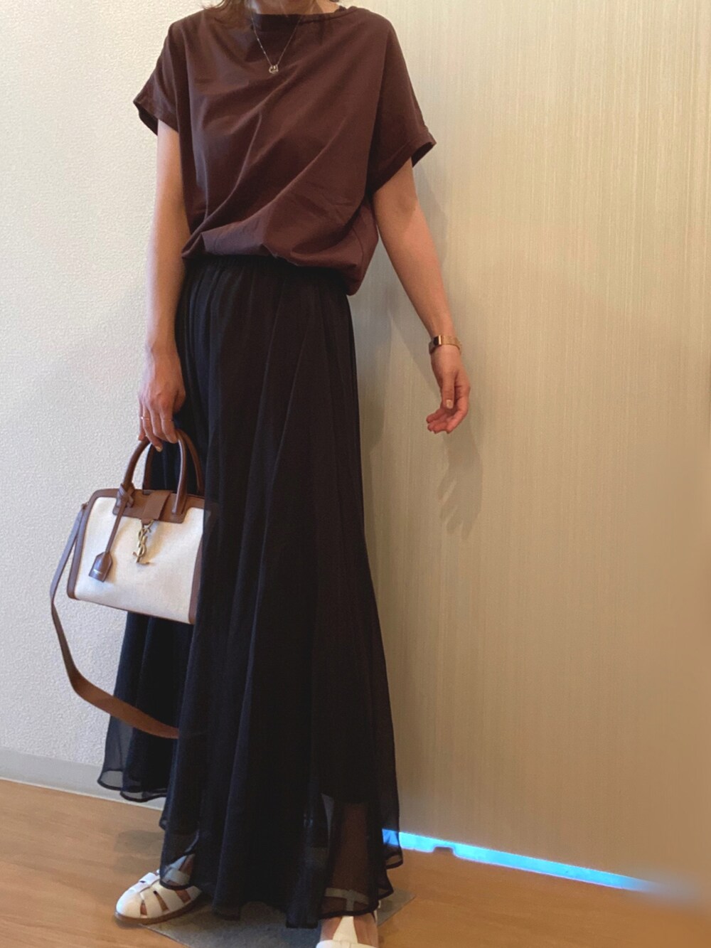 ブラウン系のTシャツ/カットソー、ブラック系のスカート、ホワイト系のサンダルを着用したレディースの夏コーディネートの2枚目の写真