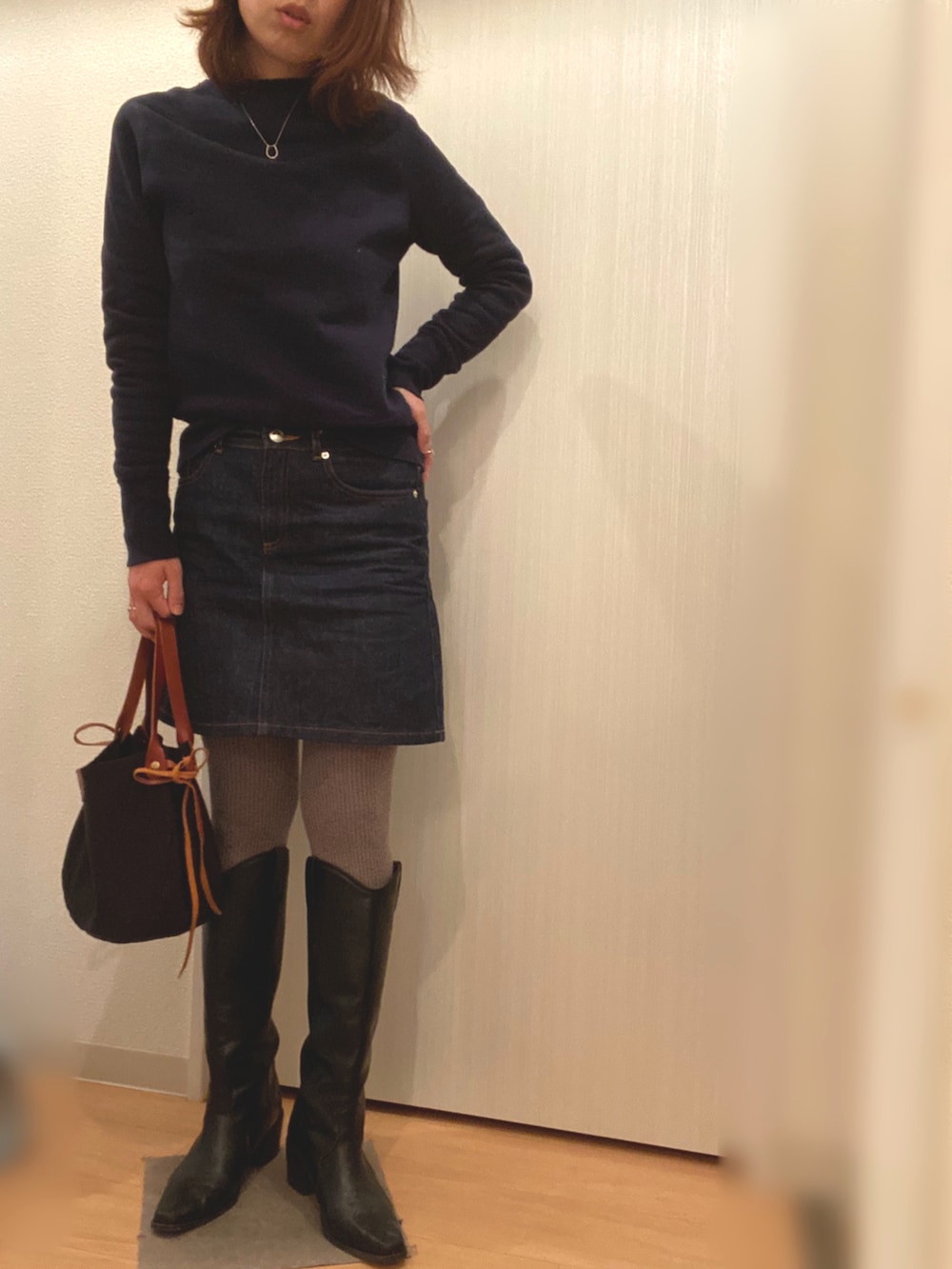 ブルー系のスウェット、ブルー系のデニムスカート、ホワイト系のその他アウターを着用したレディースの冬コーディネートの4枚目の写真