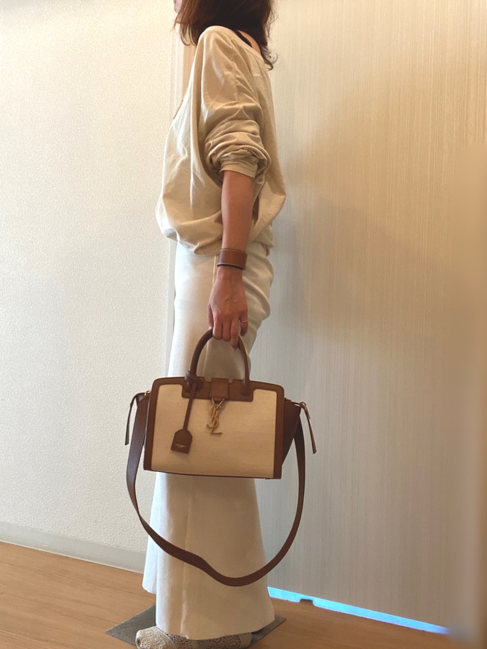 ベージュ系のTシャツ/カットソー、ホワイト系のスカート、ホワイト系のスリッポンを着用したレディースの秋コーディネートの2枚目の写真