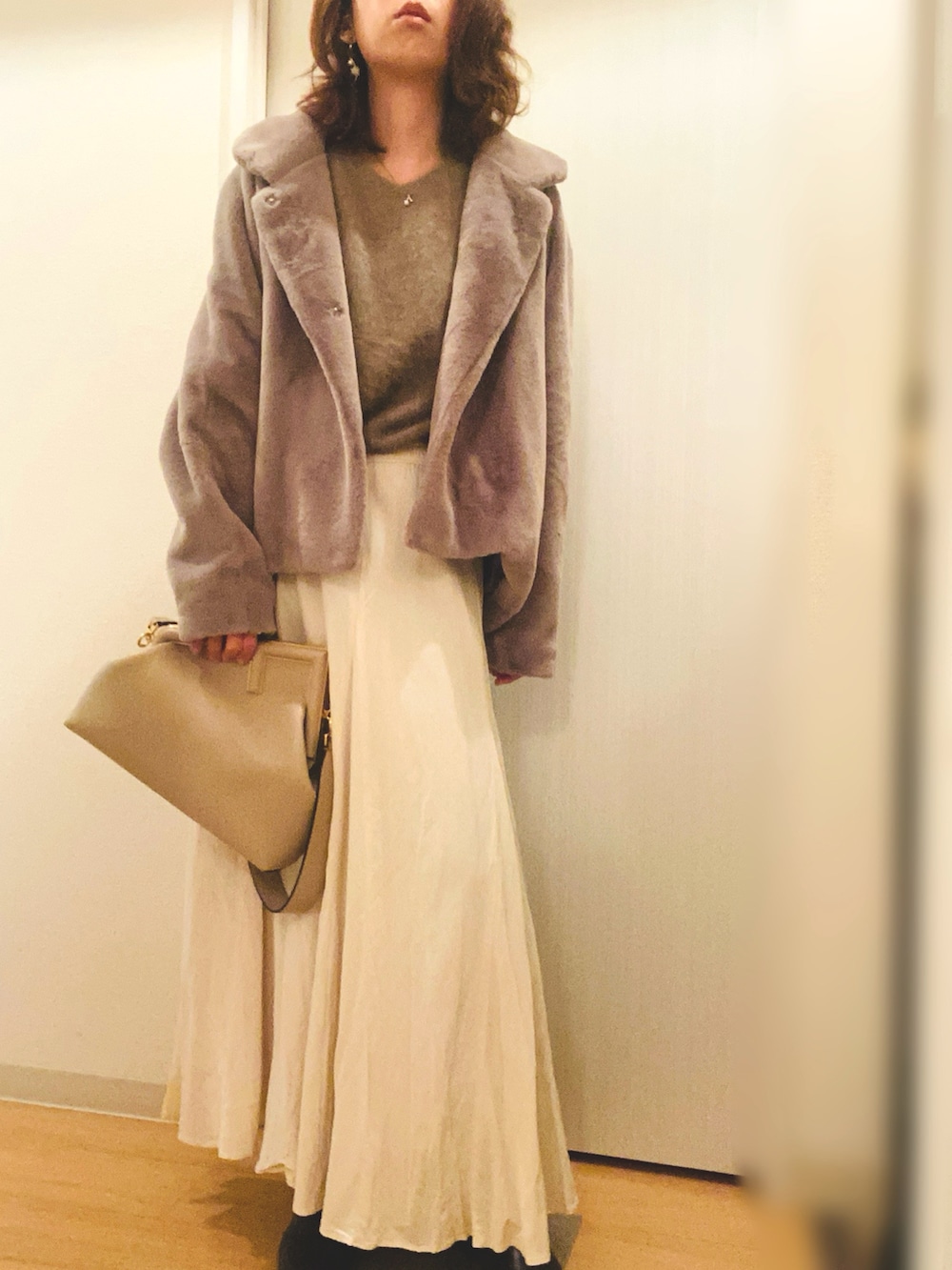 ブラウン系のニット/セーター、ホワイト系のスカート、ブラウン系のその他アウターを着用したレディースの冬コーディネートの3枚目の写真