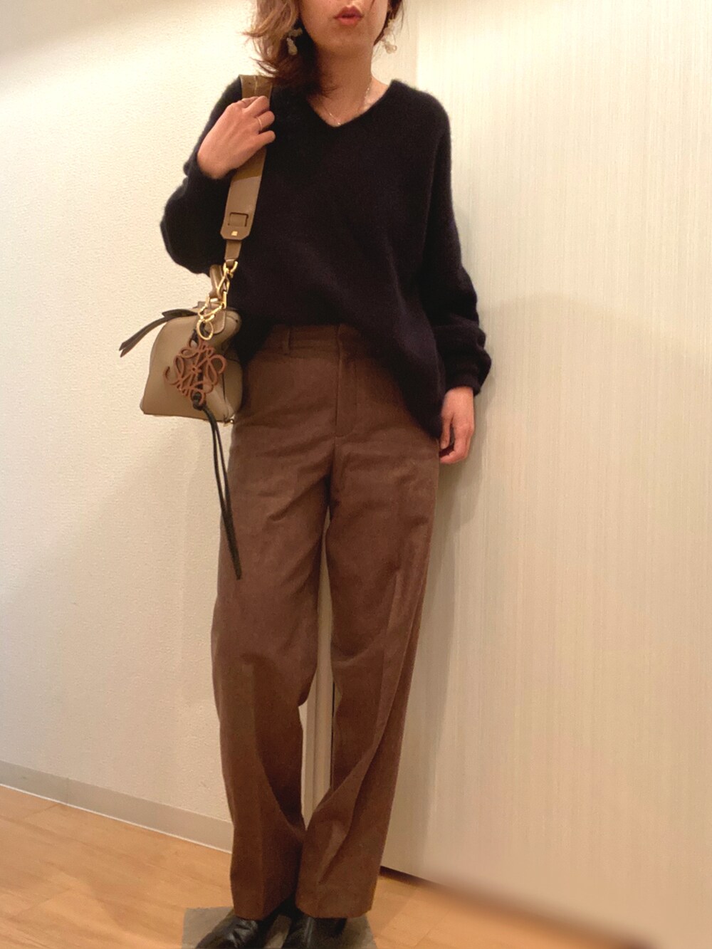 ブラック系のステンカラーコート、ブラック系のニット/セーター、ブラウン系のその他パンツを着用したレディースの冬コーディネートの2枚目の写真