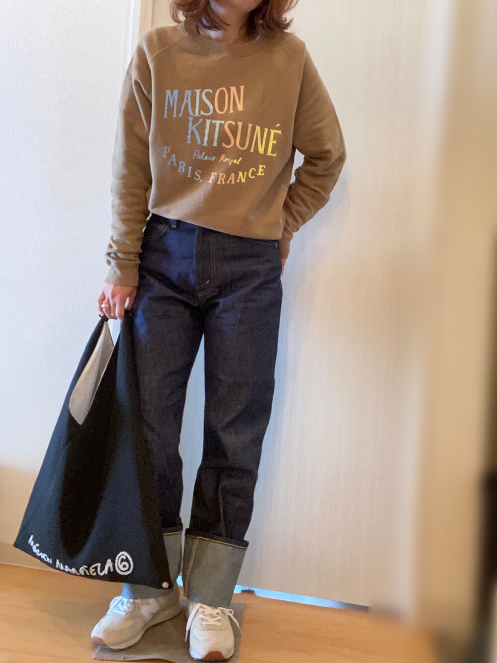 グリーン系のスウェット、ブルー系のデニムパンツ、グレー系のスニーカーを着用したレディースの秋コーディネートの2枚目の写真