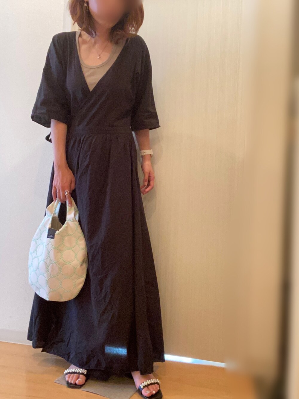 ブラック系のワンピース、ブラック系のサンダル、ホワイト系のトートバッグを着用したレディースの秋コーディネートの2枚目の写真