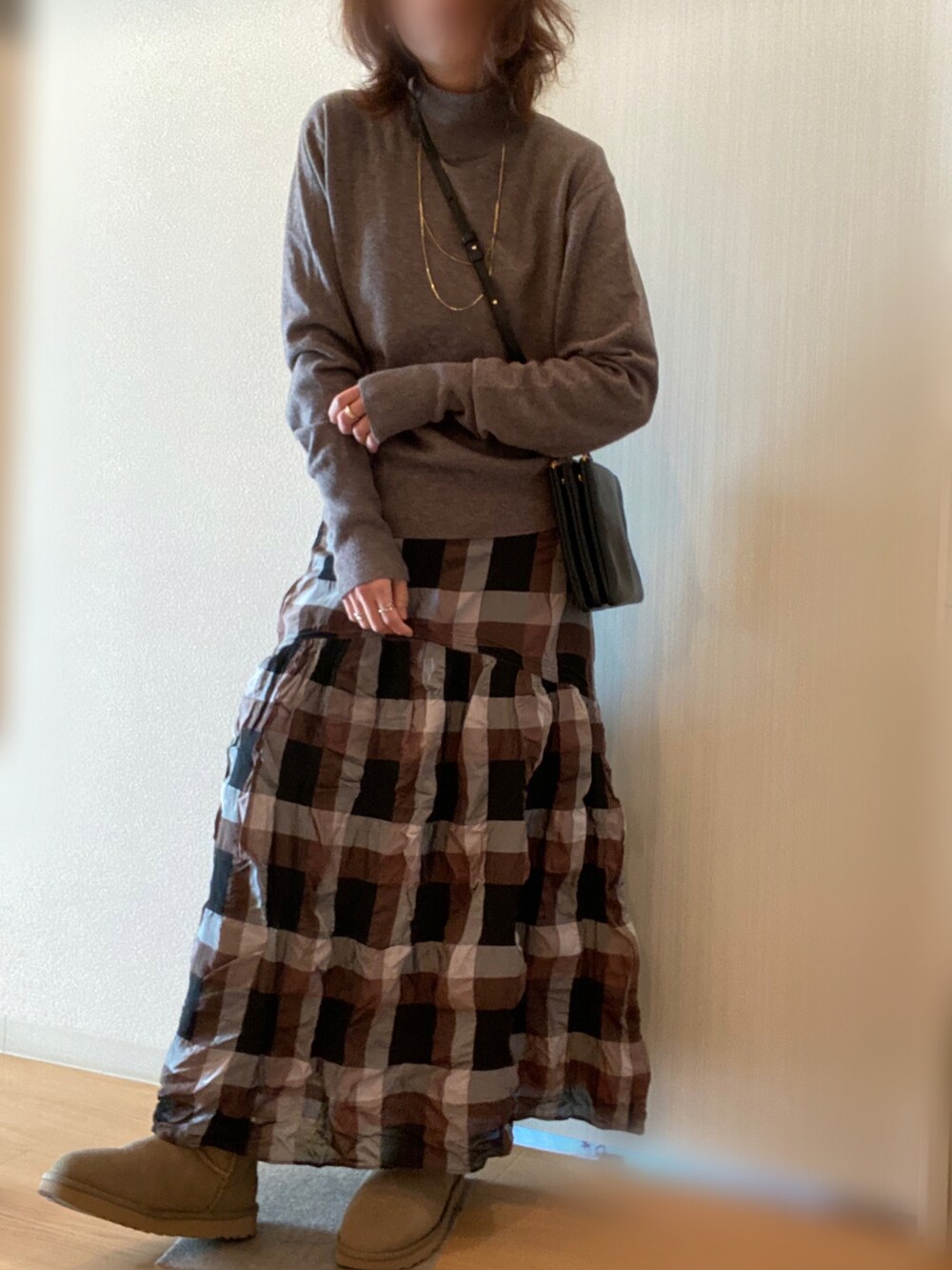 ベージュ系のダウンジャケット/コート、ベージュ系のニット/セーター、ブラック系のスカートを着用したレディースの冬コーディネートの4枚目の写真