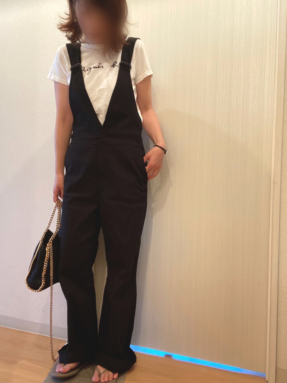 ホワイト系のTシャツ/カットソー、ブラック系のサロペット/オーバーオール、ベージュ系のサンダルを着用したレディースの夏コーディネートの2枚目の写真