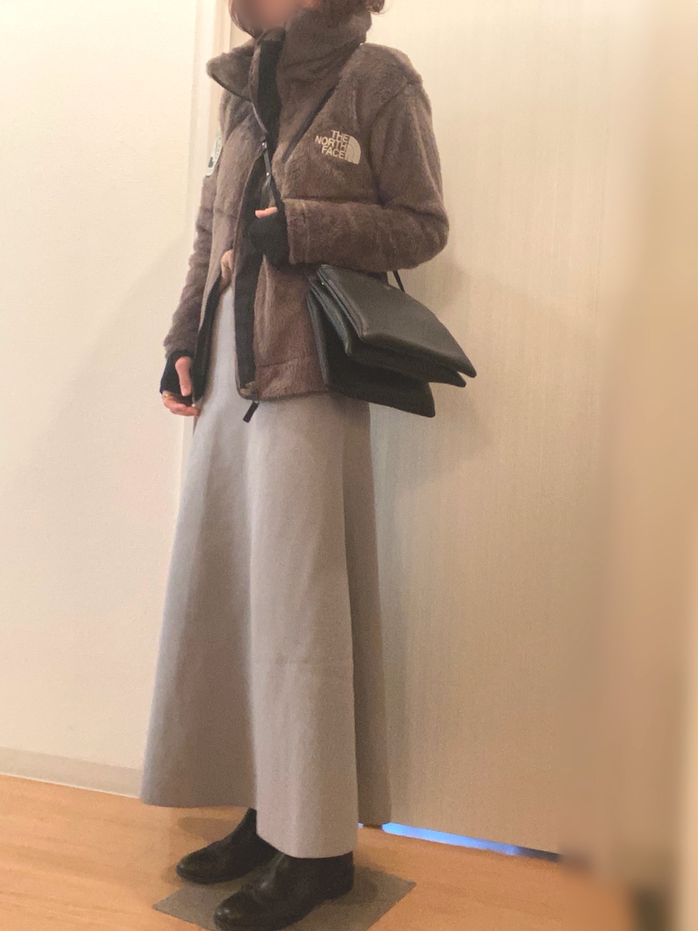 ブラウン系のブルゾン、ブラウン系のニット/セーター、グレー系のスカートを着用したレディースの冬コーディネートの2枚目の写真