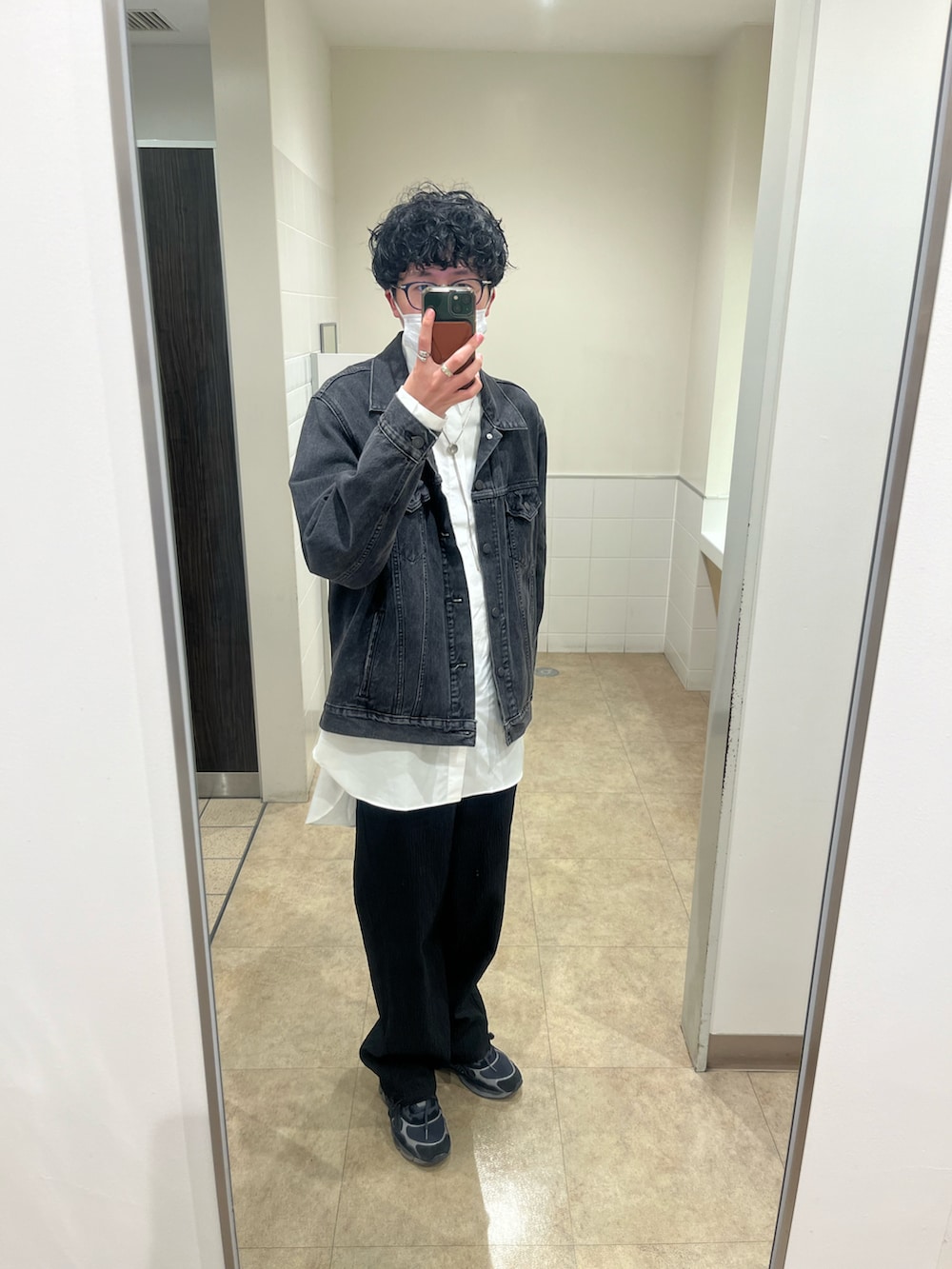 ブラック系のスラックス、ブラック系のスニーカー、ブラック系のデニムジャケットを着用したメンズの冬コーディネートの2枚目の写真