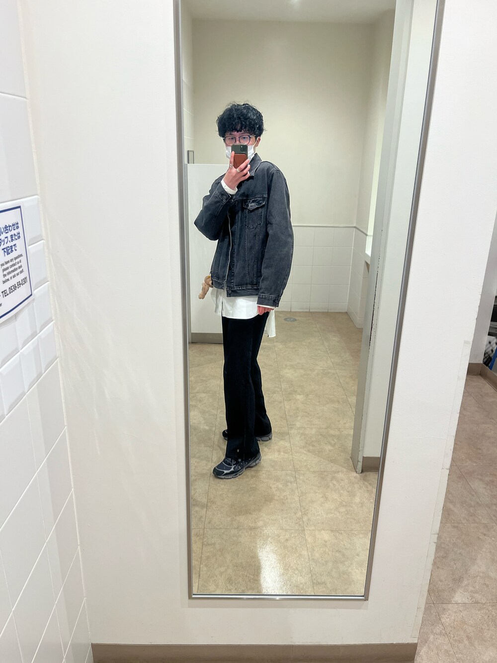 ブラック系のスラックス、ブラック系のスニーカー、ブラック系のデニムジャケットを着用したメンズの冬コーディネートの3枚目の写真