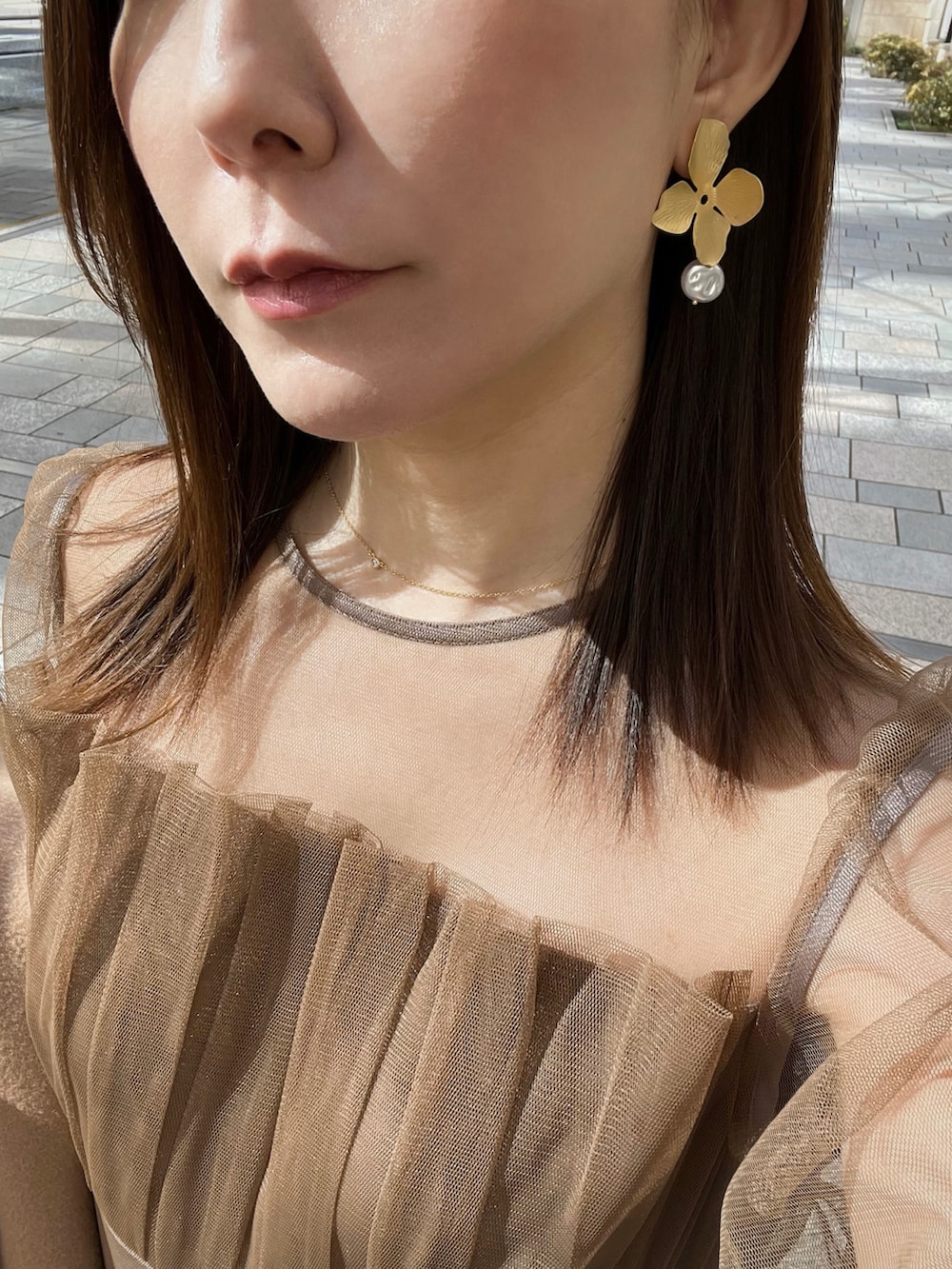 ブラウン系のドレス、ブラック系のクラッチバッグ、ブラック系のブーツを着用したレディースの春コーディネートの4枚目の写真