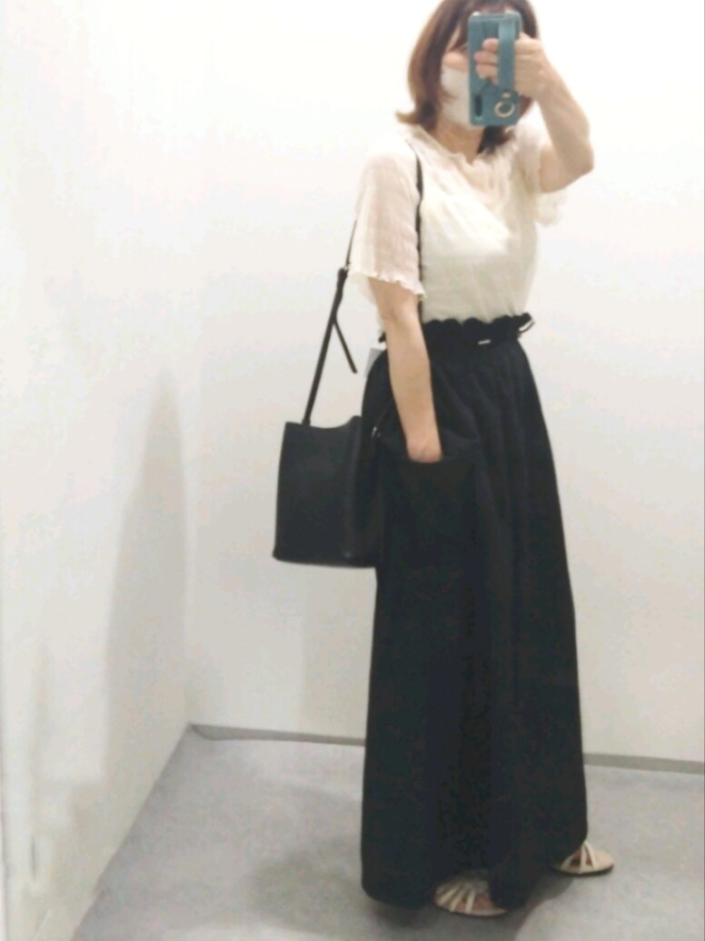 ホワイト系のシャツ/ブラウス、ベージュ系のサンダル、ブラック系のスカートを着用したレディースの夏コーディネートの2枚目の写真