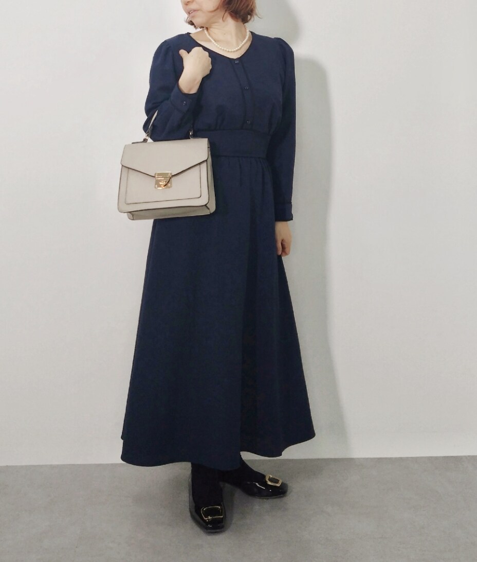 ブルー系のワンピース、ブラック系のパンプスを着用したレディースの冬コーディネートの2枚目の写真