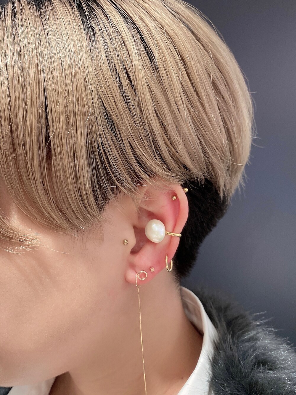 ゴールド系のイヤーカフを着用したレディースの秋コーディネートの2枚目の写真