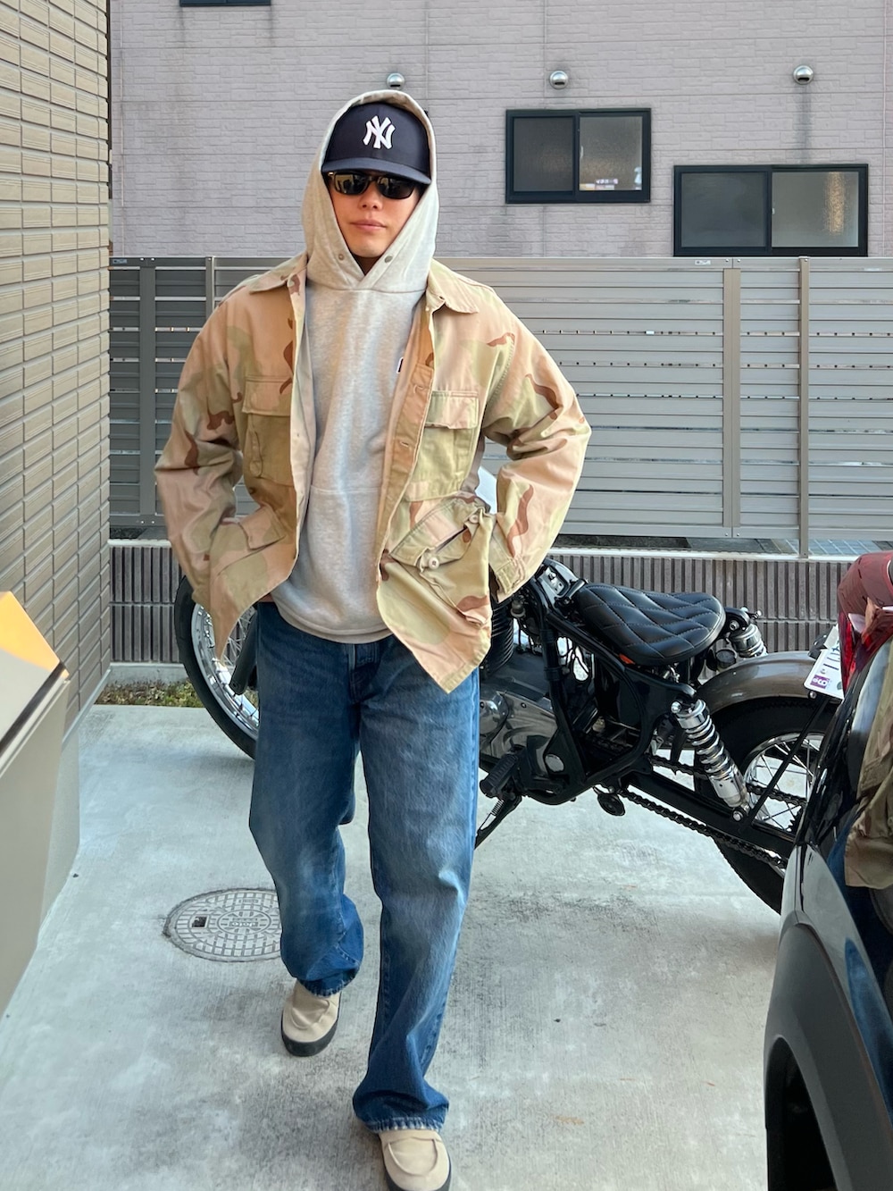 ベージュ系のローファー、ブルー系のデニムパンツ、その他のミリタリージャケットを着用したメンズの冬コーディネートの2枚目の写真