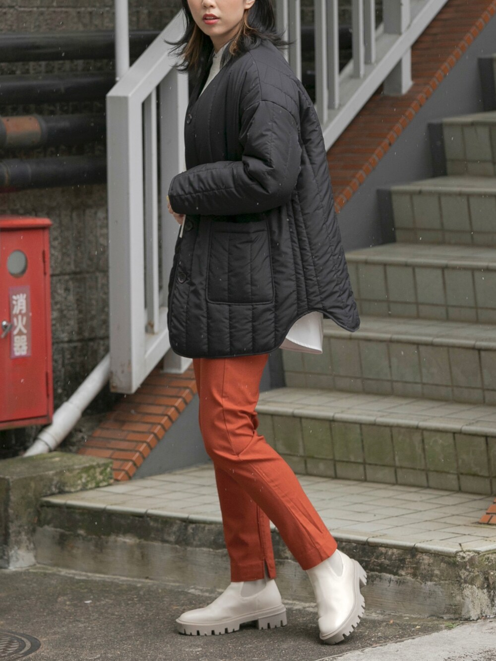 ブラック系のその他アウター、ベージュ系のスウェット、ホワイト系のブーツを着用したレディースの冬コーディネートの2枚目の写真