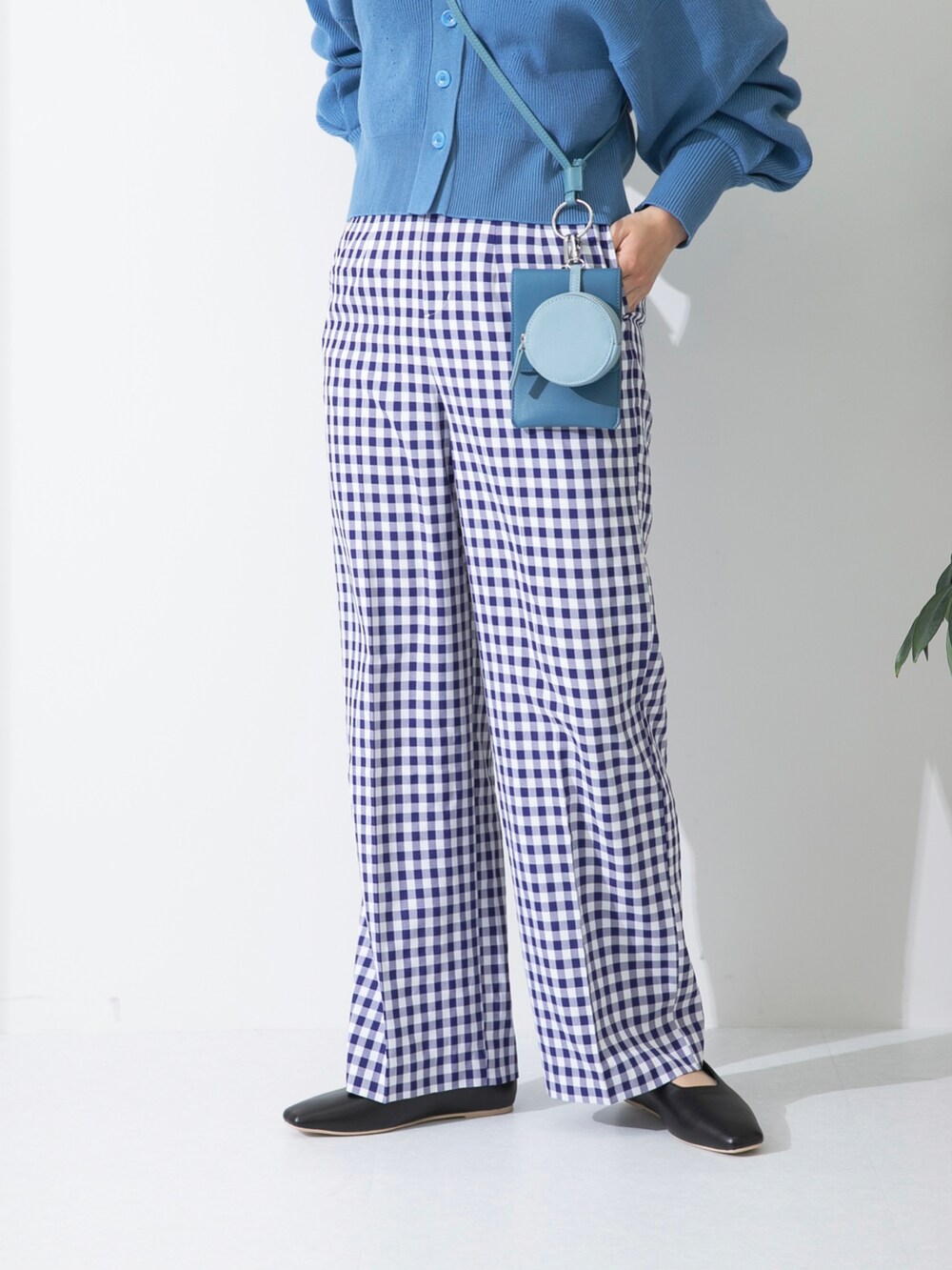 ブルー系のカーディガン/ボレロ、ブルー系のショルダーバッグ、ホワイト系のTシャツ/カットソーを着用したレディースの冬コーディネートの4枚目の写真