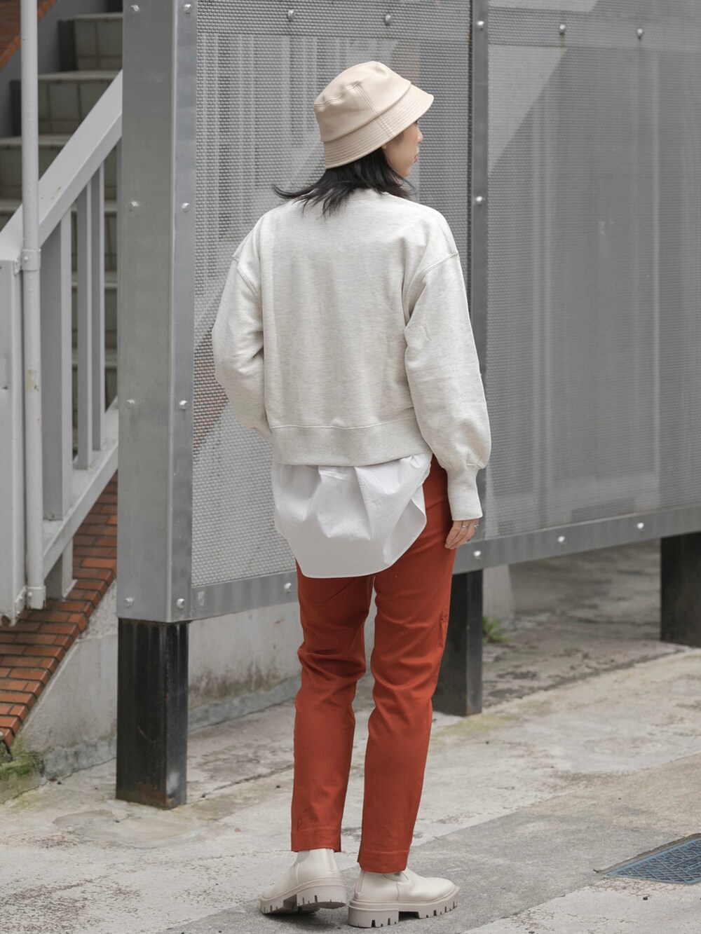 ベージュ系のスウェット、ホワイト系のシャツ/ブラウス、ホワイト系のブーツを着用したレディースの冬コーディネートの3枚目の写真