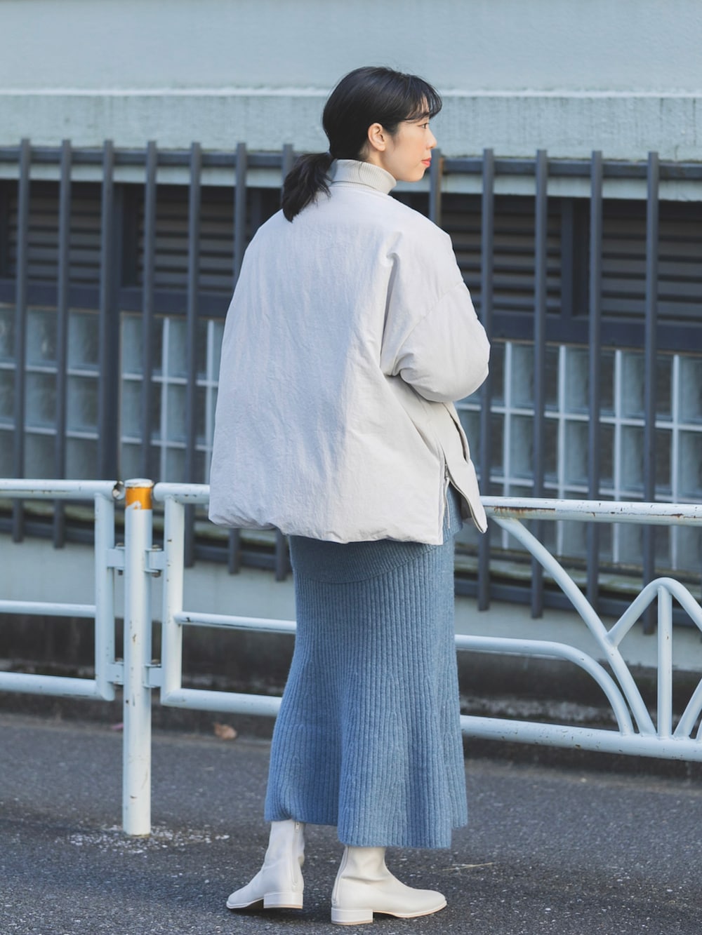 ベージュ系のダウンジャケット/コート、ブルー系のスカート、ホワイト系のその他シューズを着用したレディースの冬コーディネートの2枚目の写真