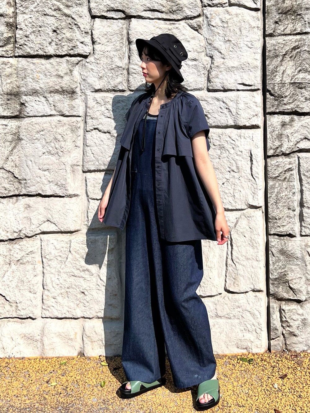 ブルー系のサロペット/オーバーオール、ホワイト系のタンクトップ、グリーン系のサンダルを着用したレディースの春コーディネートの3枚目の写真