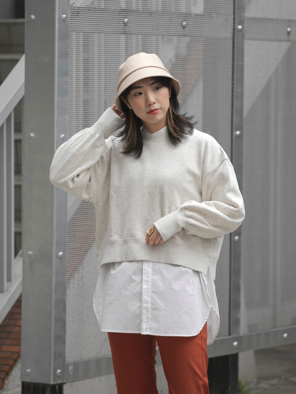 ベージュ系のスウェット、ホワイト系のシャツ/ブラウス、ホワイト系のブーツを着用したレディースの冬コーディネートの2枚目の写真