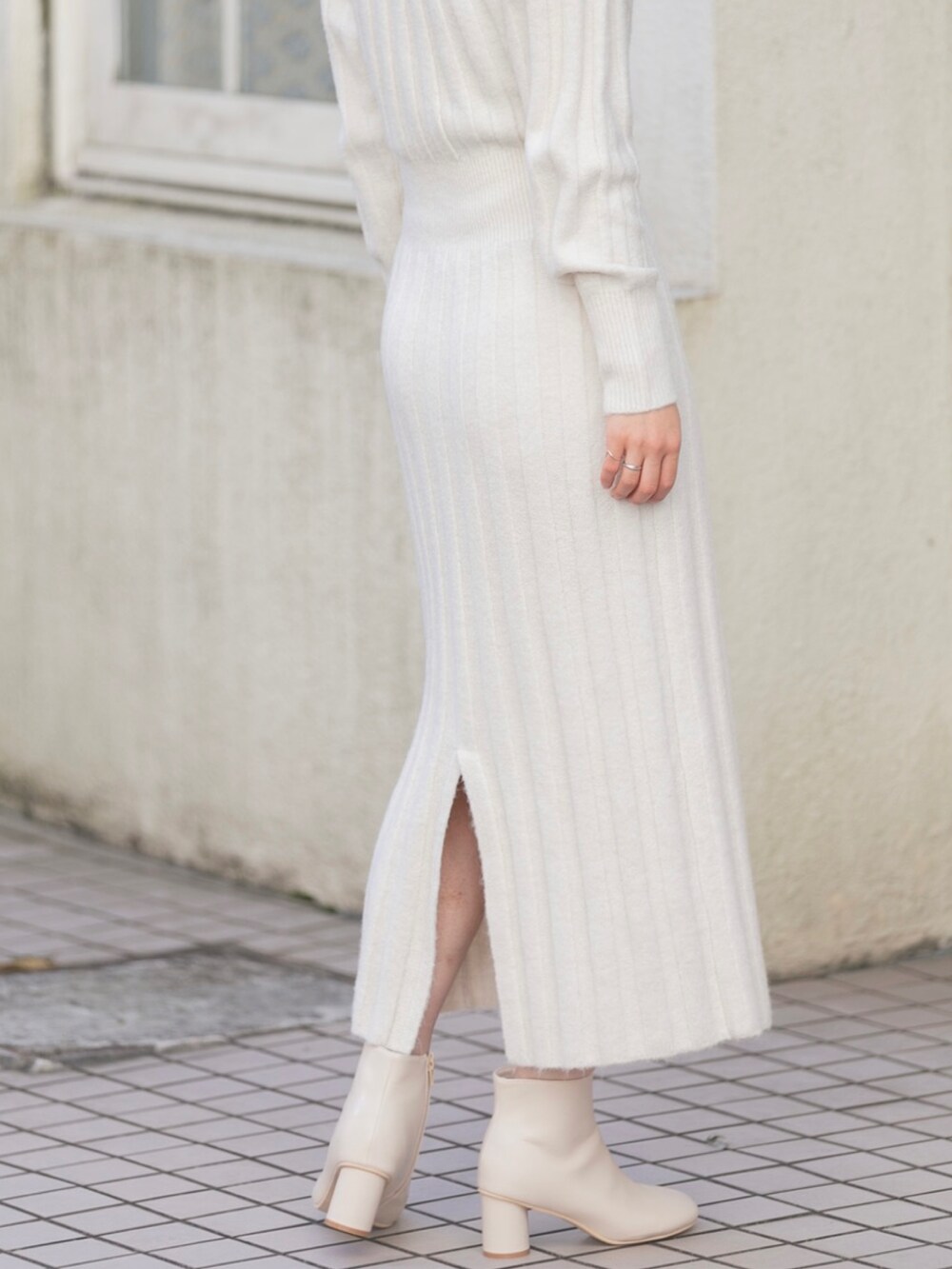 ホワイト系のナイロンジャケット、ホワイト系のワンピース、ホワイト系のブーツを着用したレディースの冬コーディネートの5枚目の写真