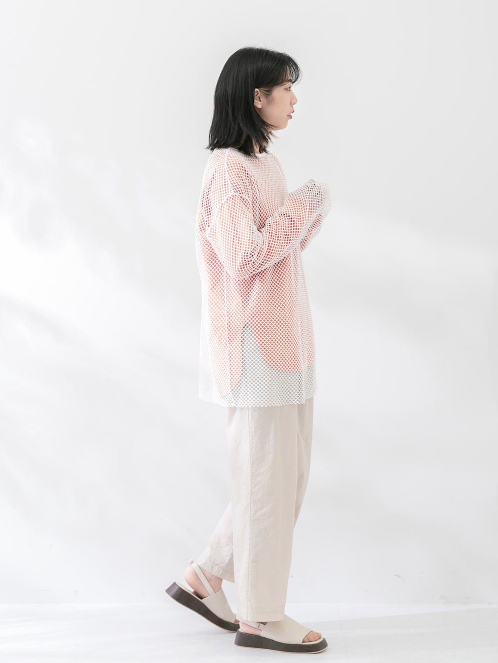 ホワイト系のTシャツ/カットソー、オレンジ系のTシャツ/カットソー、ホワイト系のサンダルを着用したレディースの春コーディネートの3枚目の写真