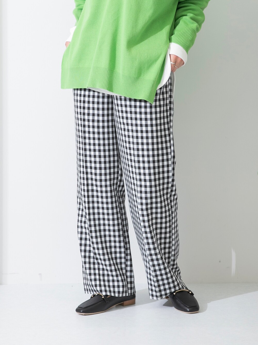 グリーン系のニット/セーター、ホワイト系のTシャツ/カットソー、ブラック系のローファーを着用したレディースの春コーディネートの4枚目の写真