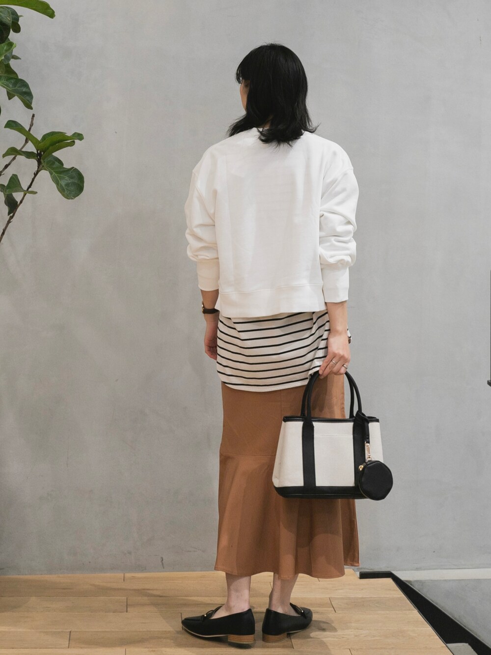 ホワイト系のスウェット、ホワイト系のTシャツ/カットソー、ピンク系のスカートを着用したレディースの冬コーディネートの3枚目の写真