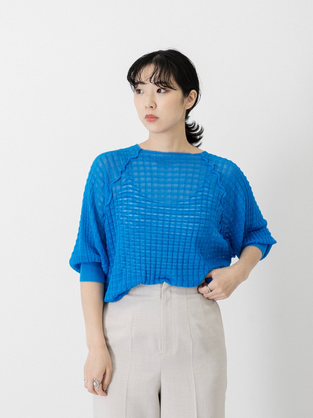 ブルー系のニット/セーター、ベージュ系のその他パンツ、ブラック系のバッグを着用したレディースの夏コーディネートの2枚目の写真