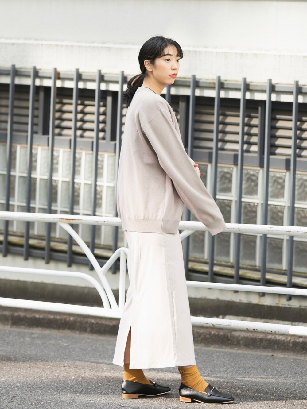 ベージュ系のカーディガン/ボレロ、ホワイト系のニット/セーター、ホワイト系のスカートを着用したレディースの冬コーディネートの2枚目の写真