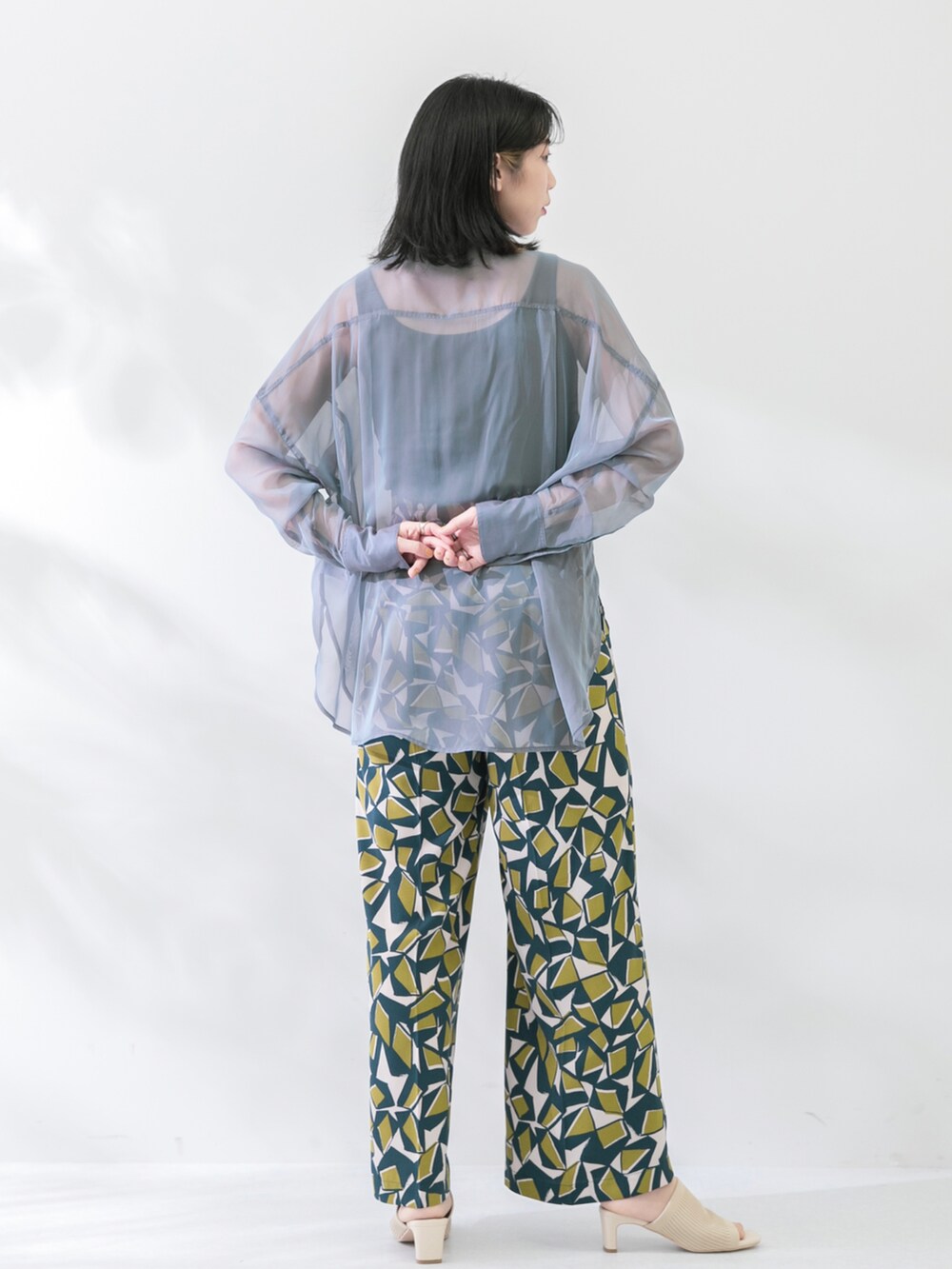 ブルー系のシャツ/ブラウス、グリーン系のその他パンツ、ブラック系のTシャツ/カットソーを着用したレディースの春コーディネートの3枚目の写真