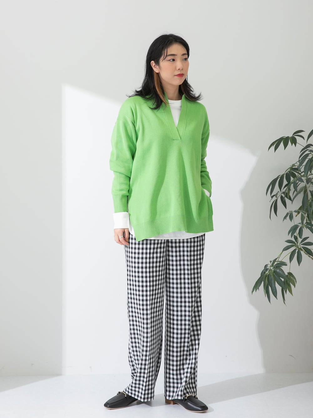 グリーン系のニット/セーター、ホワイト系のTシャツ/カットソー、ブラック系のローファーを着用したレディースの春コーディネートの2枚目の写真