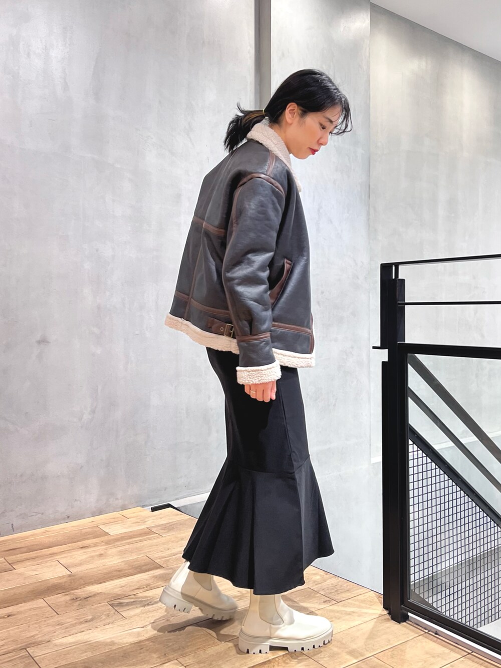 ブラック系のブルゾン、ブラック系のスカート、ホワイト系のブーツを着用したレディースの冬コーディネートの2枚目の写真