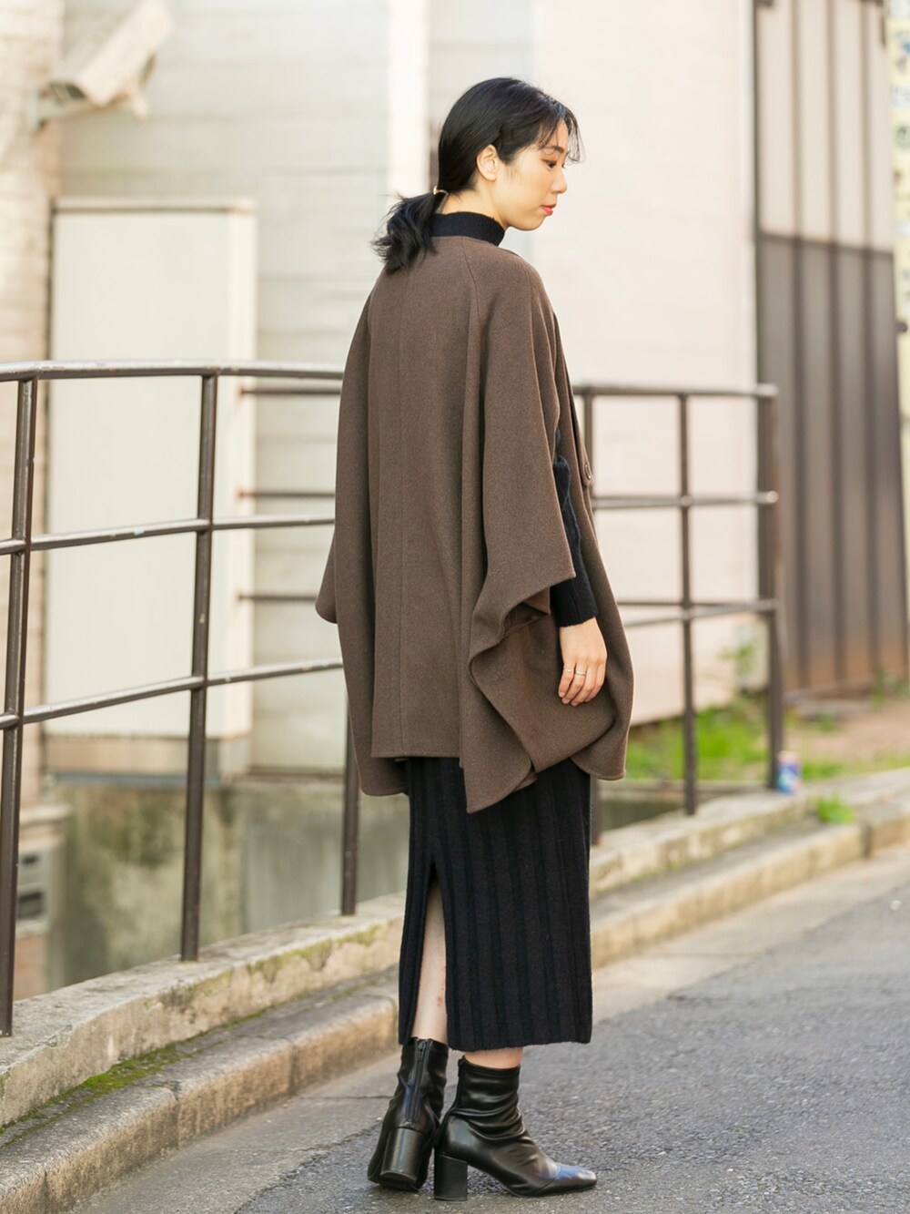 ブラウン系のその他アウター、ブラック系のワンピース、ブラック系のブーツを着用したレディースの冬コーディネートの2枚目の写真