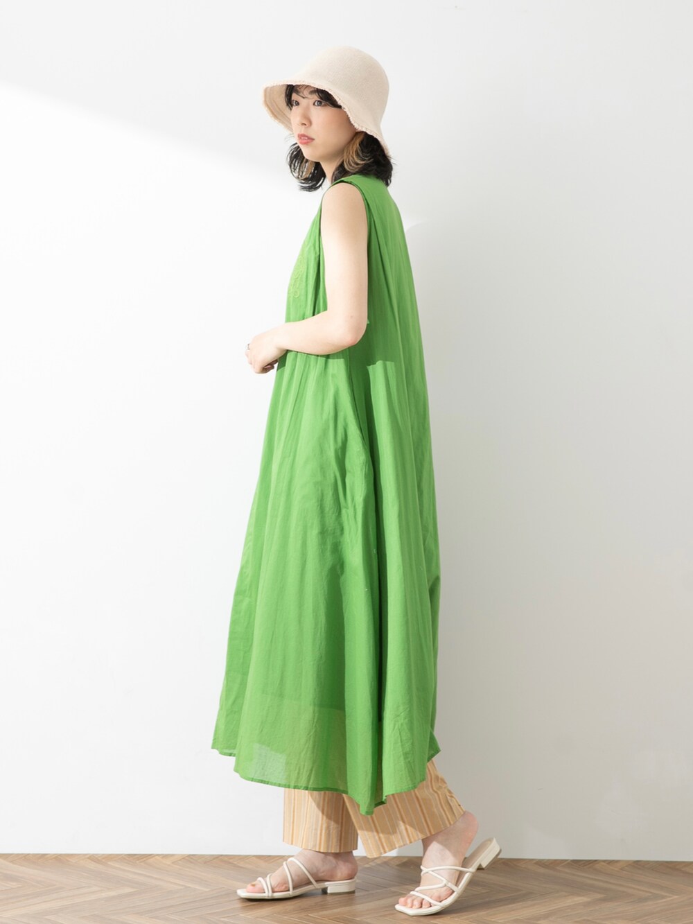 グリーン系のワンピース、ベージュ系のその他パンツ、ホワイト系のサンダルを着用したレディースの春コーディネートの2枚目の写真
