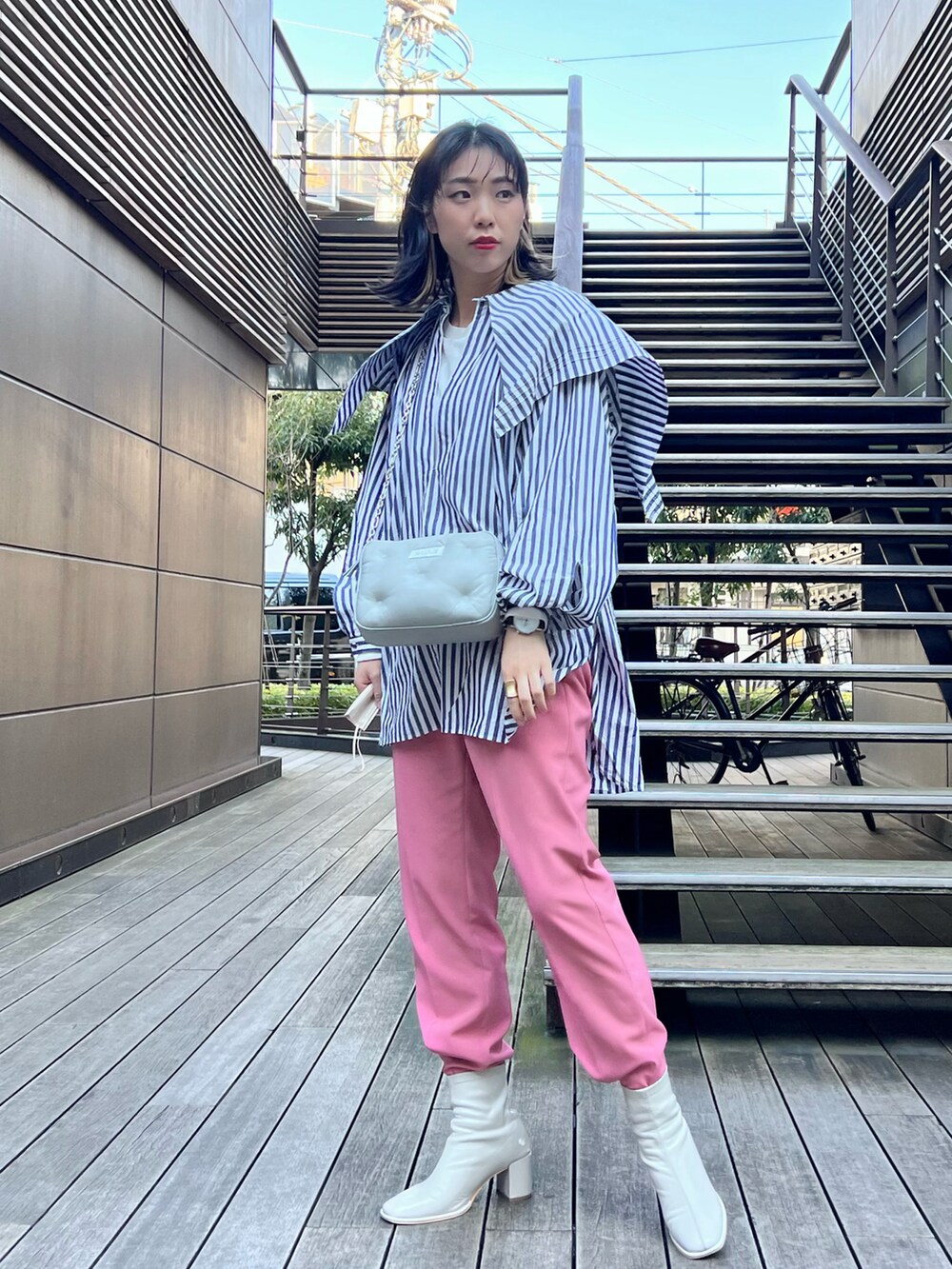 ブルー系のトップス、ピンク系のその他パンツ、ホワイト系のブーツを着用したレディースの春コーディネートの2枚目の写真