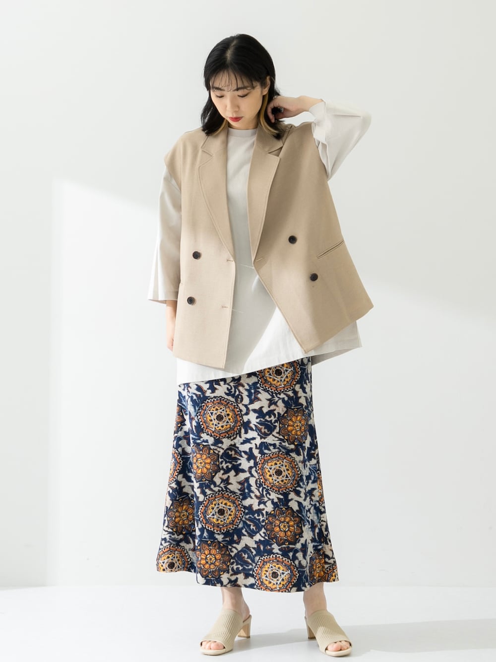 ベージュ系のTシャツ/カットソー、ベージュ系のその他アウター、ホワイト系のサンダルを着用したレディースの春コーディネートの2枚目の写真