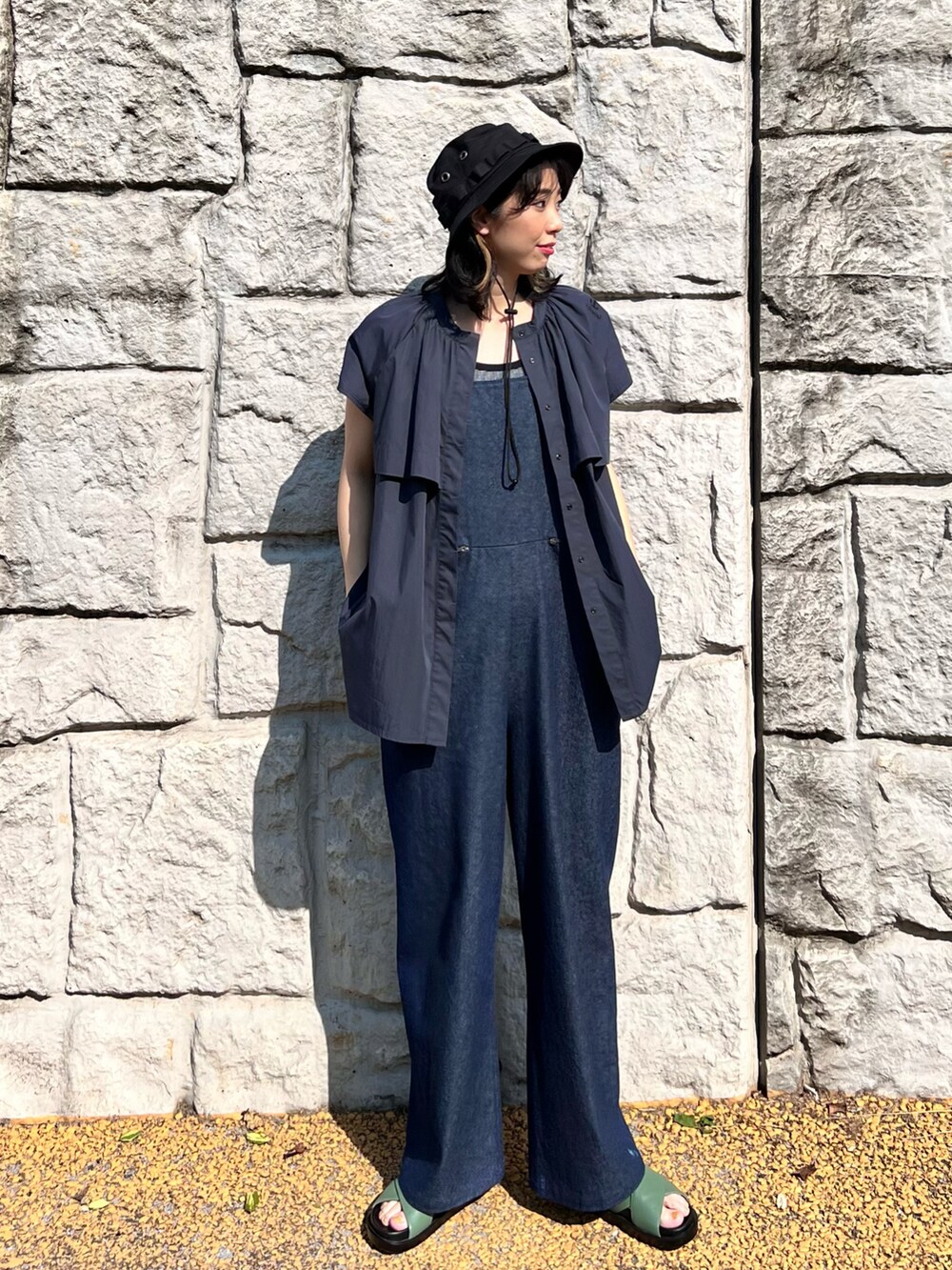 ブルー系のサロペット/オーバーオール、ホワイト系のタンクトップ、グリーン系のサンダルを着用したレディースの春コーディネートの2枚目の写真