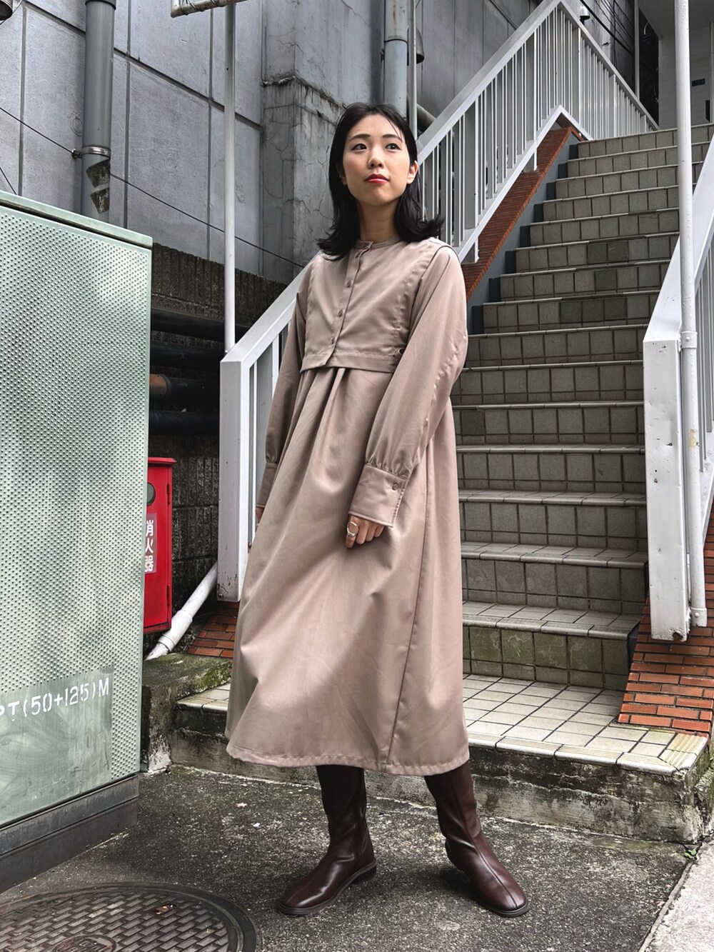 ベージュ系のワンピース、ブラウン系のブーツ、ブラウン系のブルゾンを着用したレディースの冬コーディネートの3枚目の写真