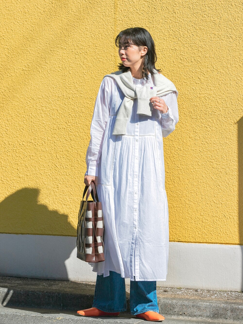 ホワイト系のスウェット、ホワイト系のワンピース/ドレス、ブルー系のデニムパンツを着用したレディースの春コーディネートの2枚目の写真