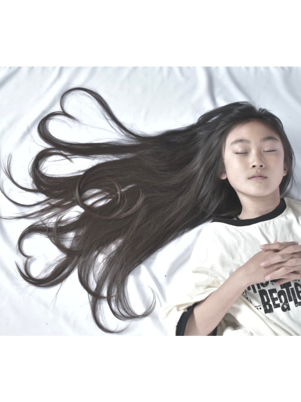 ホワイト系のTシャツ/カットソー、ブラック系のスカート、ブラック系のバッグを着用したキッズの春コーディネートの3枚目の写真