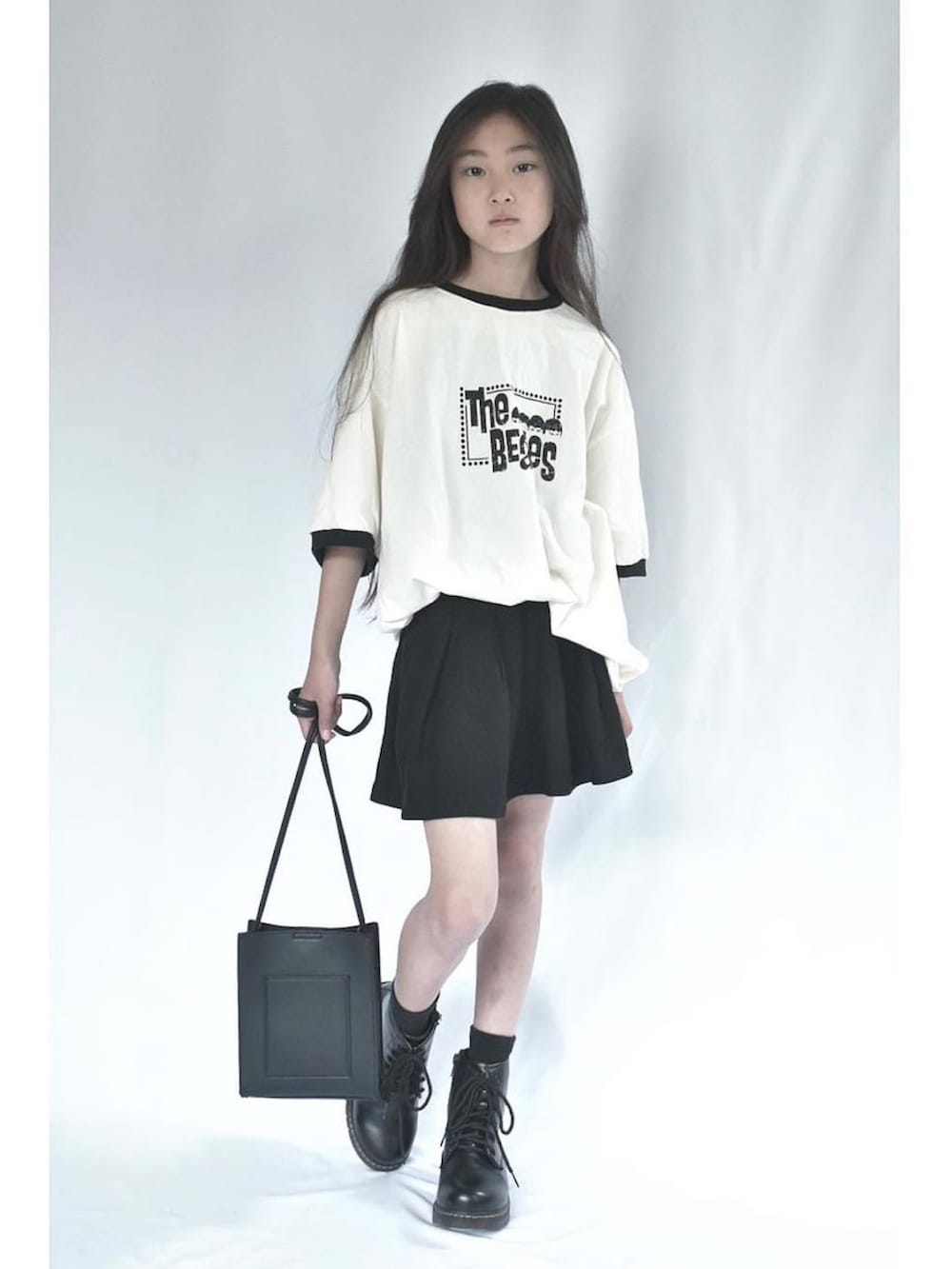 ホワイト系のTシャツ/カットソー、ブラック系のスカート、ブラック系のバッグを着用したキッズの春コーディネートの2枚目の写真