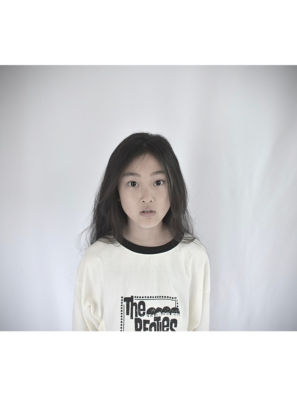 ホワイト系のTシャツ/カットソー、ブラック系のスカート、ブラック系のバッグを着用したキッズの春コーディネートの4枚目の写真