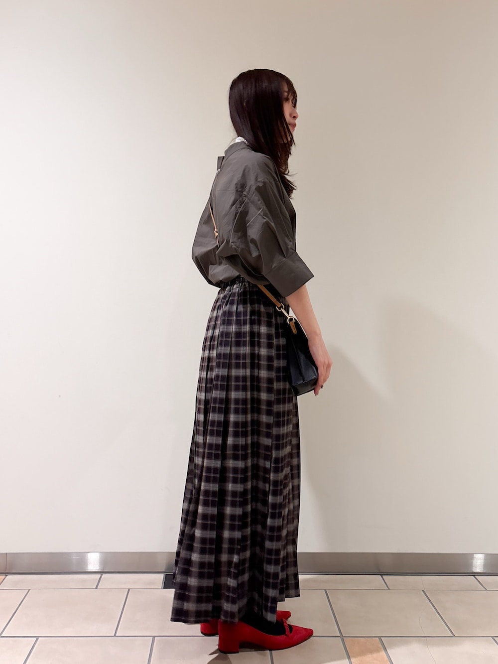 レッド系のパンプス、ブラック系のショルダーバッグ、グレー系のシャツ/ブラウスを着用したレディースの春コーディネートの3枚目の写真