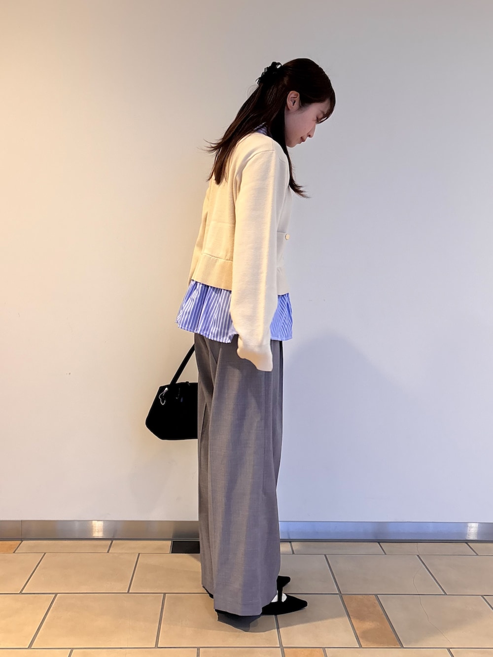 ホワイト系のニット/セーター、グレー系のその他パンツ、ブラック系のトートバッグを着用したレディースの春コーディネートの3枚目の写真