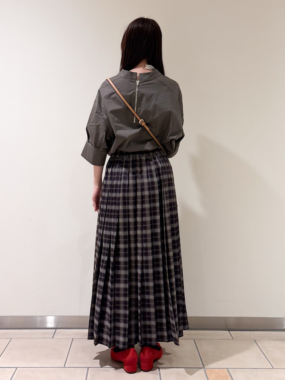 レッド系のパンプス、ブラック系のショルダーバッグ、グレー系のシャツ/ブラウスを着用したレディースの春コーディネートの4枚目の写真