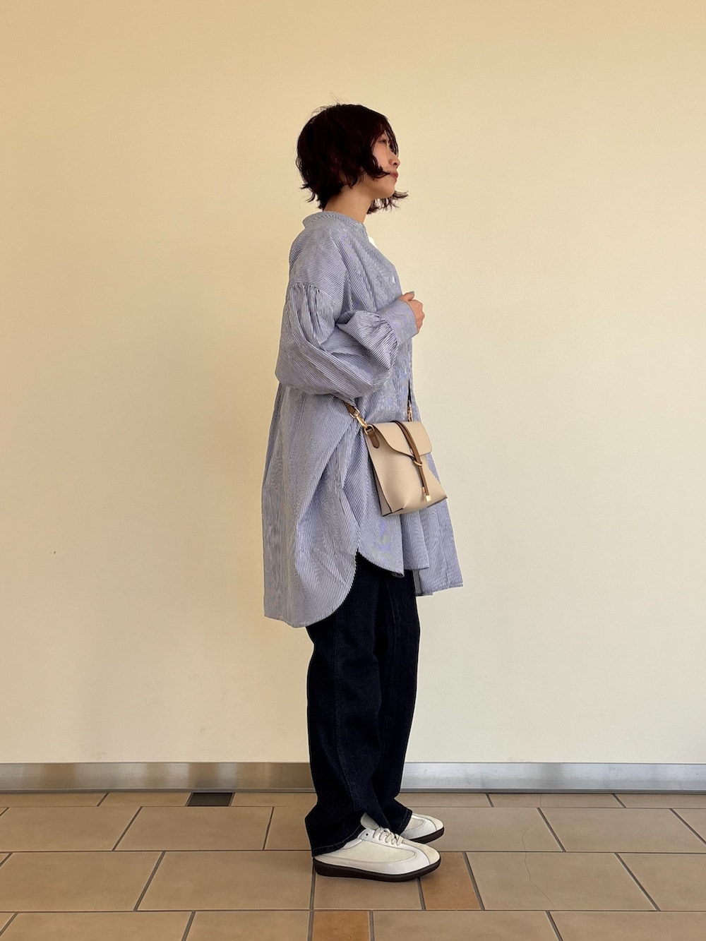 ブルー系のシャツ/ブラウス、ホワイト系のTシャツ/カットソー、ブルー系のデニムパンツを着用したレディースの春コーディネートの2枚目の写真