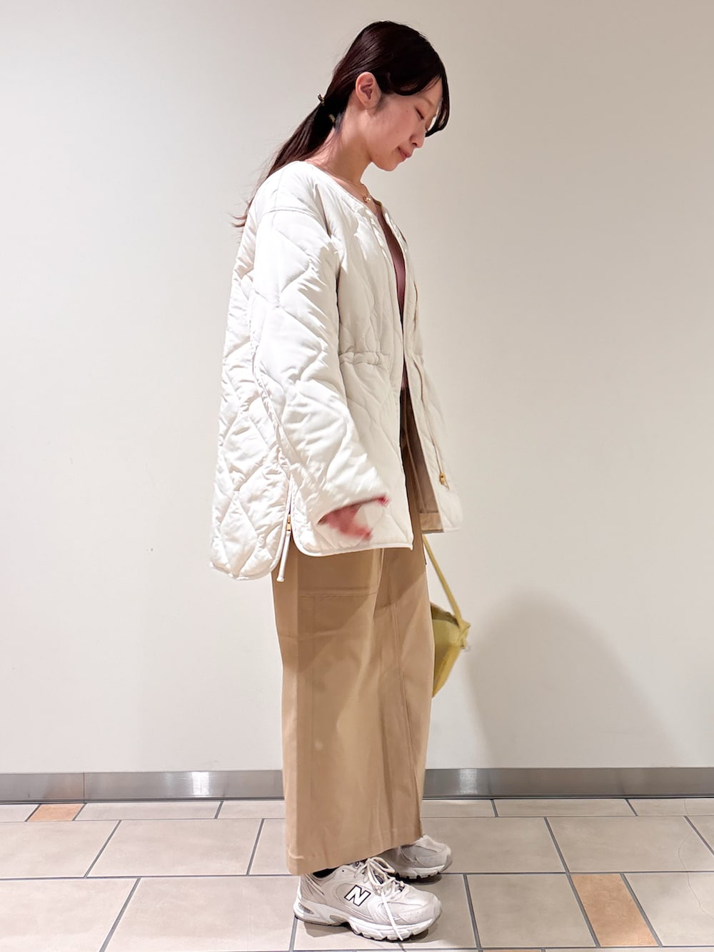 ホワイト系のブルゾン、ベージュ系のスカート、ピンク系のニット/セーターを着用したレディースの冬コーディネートの2枚目の写真