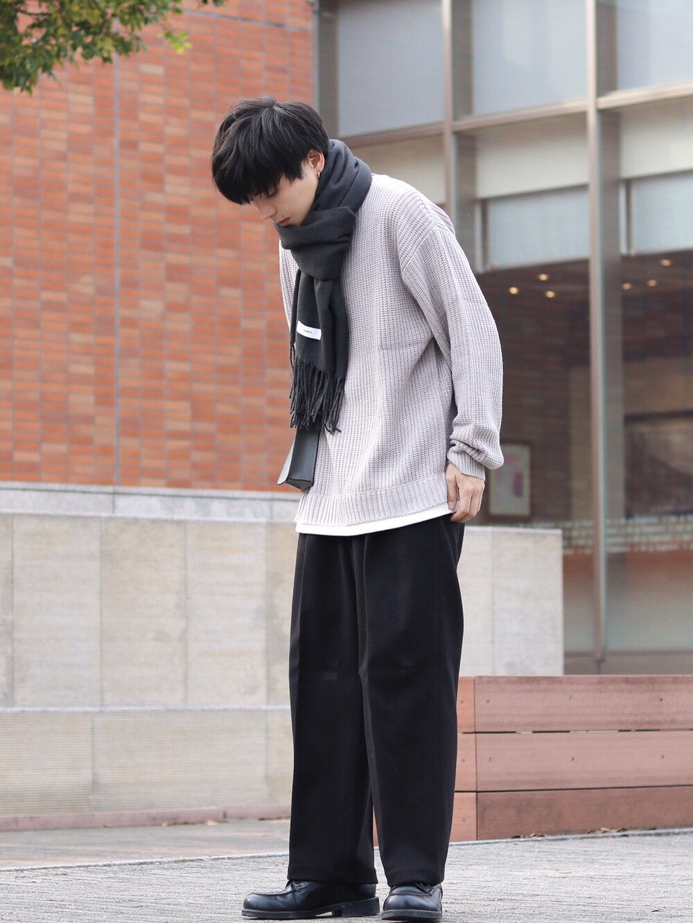 ブラック系のその他パンツ、グレー系のニット/セーター、グレー系のショルダーバッグを着用したメンズの秋コーディネートの3枚目の写真